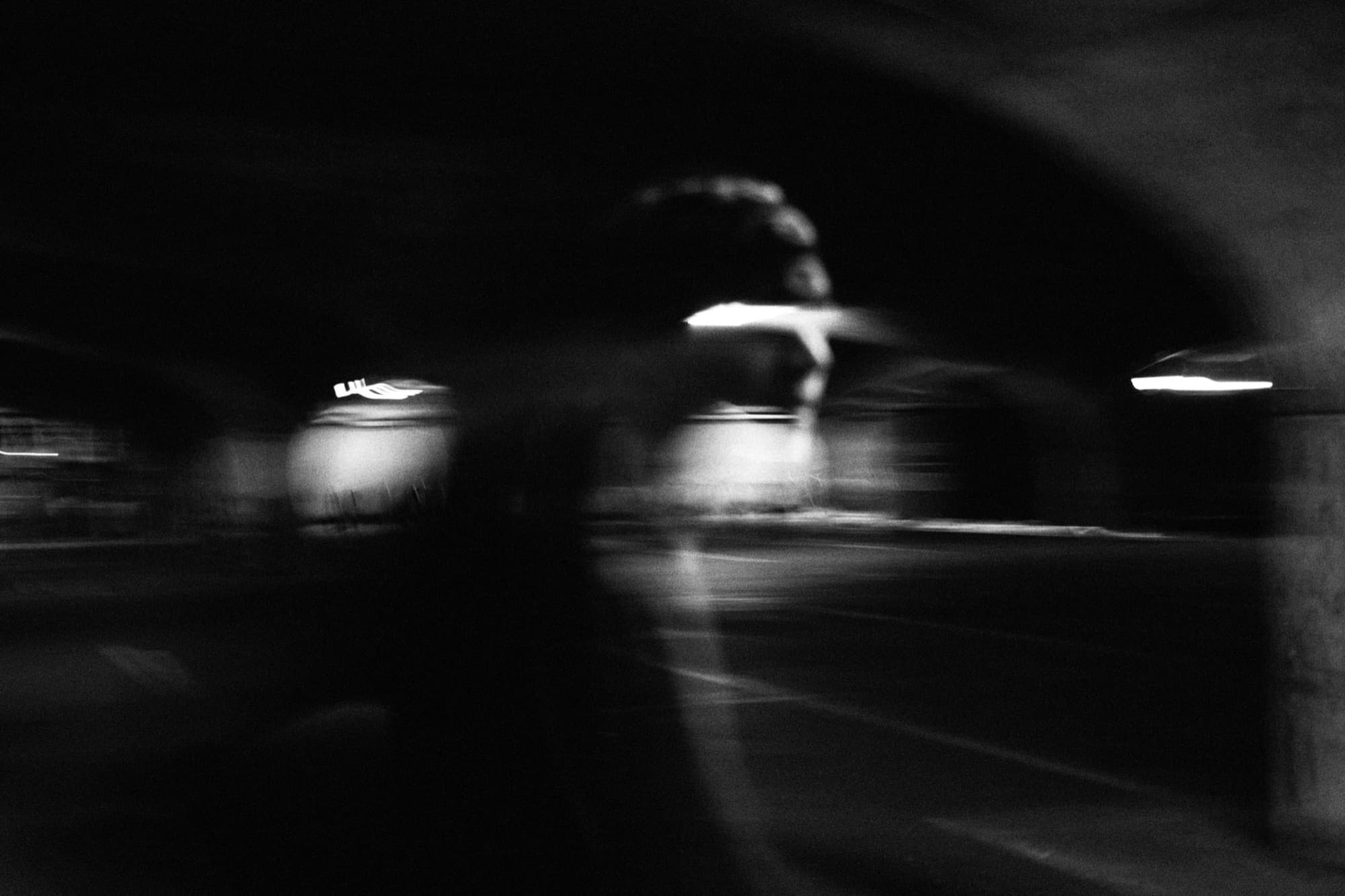 Long-exposure night street, headlights smeared across the frame